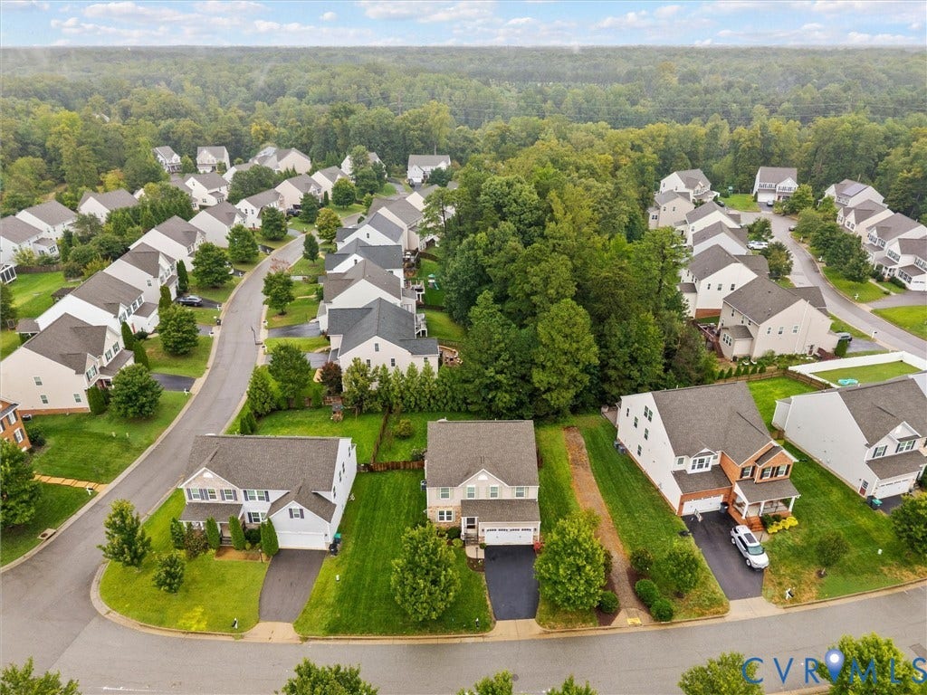 9990 Orchard Meadow Road, Mechanicsville, VA 23116 Suburban streetscape featuring detached homes with asphalt driveways, two-car garages, and landscaped front yards
