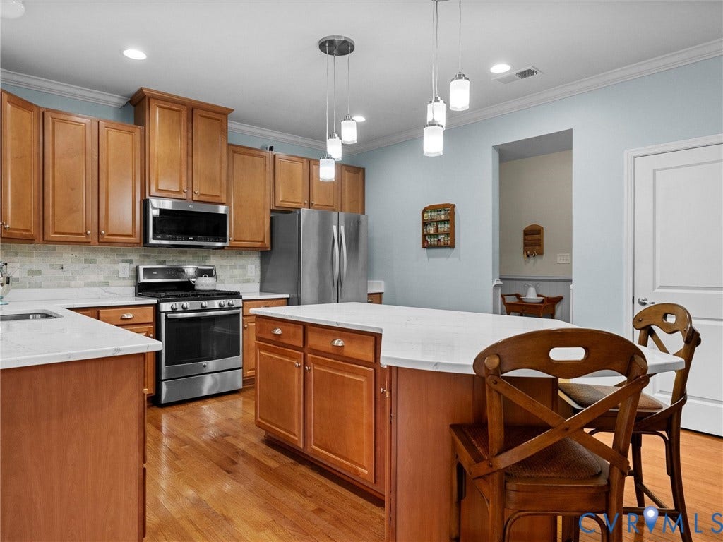 9990 Orchard Meadow Road, Mechanicsville, VA 23116 Kitchen featuring wood-finish cabinetry, stainless steel appliances, a center island with countertop seating, and recessed lighting