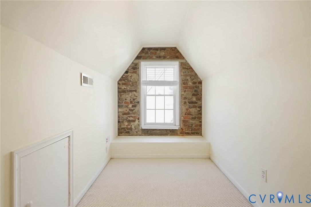 1713 Wilmington Avenue, Richmond, VA 23227 Exposed brick accent wall, white-framed window, built-in window bench, light-colored carpeting, sloped ceilings