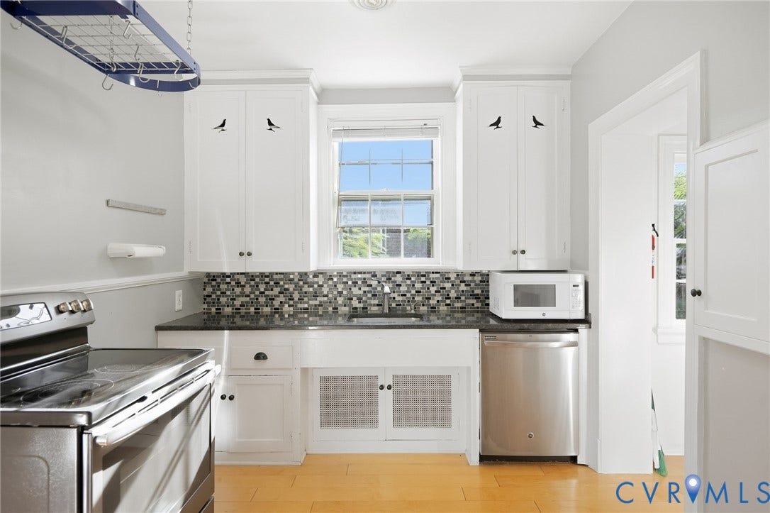 1713 Wilmington Avenue, Richmond, VA 23227 White cabinetry with dark hardware, dark countertops, a mosaic tile backsplash, stainless steel dishwasher, and wood-finish flooring