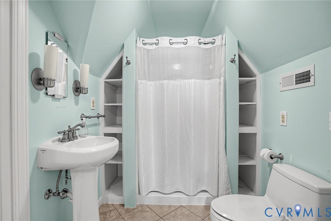 1713 Wilmington Avenue, Richmond, VA 23227 Pedestal sink with chrome fixtures, tile flooring, built-in shelving, and a shower with a white curtain