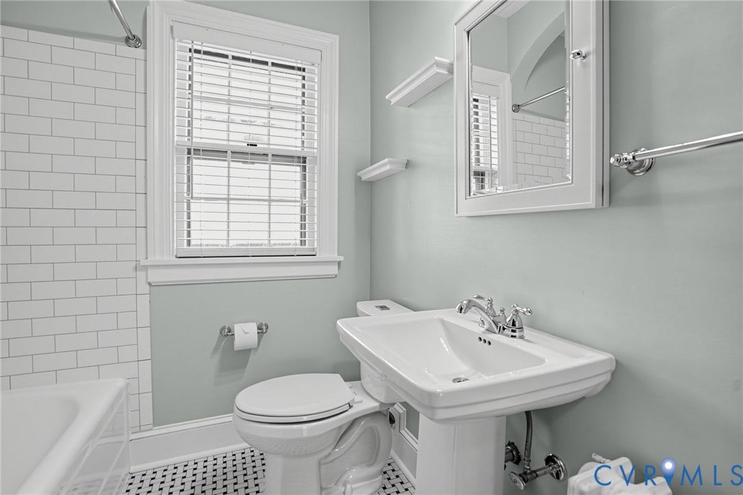1713 Wilmington Avenue, Richmond, VA 23227 White subway tile shower surround, black and white mosaic tile flooring, pedestal sink with chrome fixtures, and a mirrored medicine cabinet