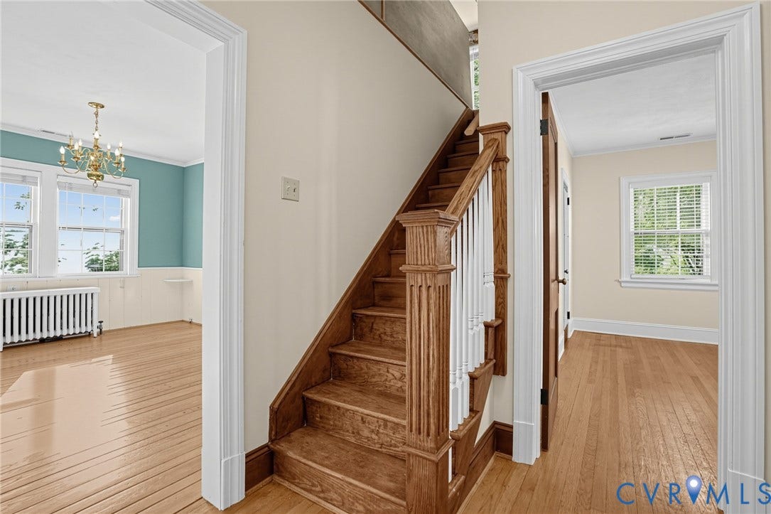 1713 Wilmington Avenue, Richmond, VA 23227 Hardwood flooring throughout, a traditional wood staircase, white balusters, and a brass chandelier