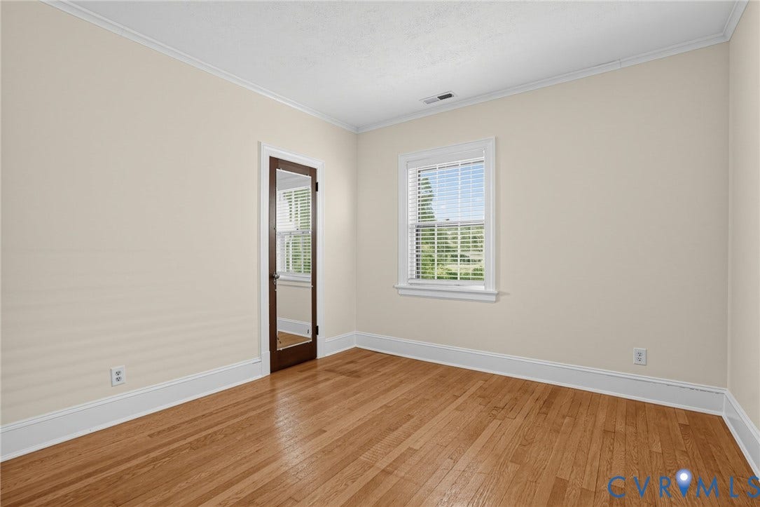 1713 Wilmington Avenue, Richmond, VA 23227 Hardwood flooring, crown molding, white trim, window with blinds, and a full-length mirrored door