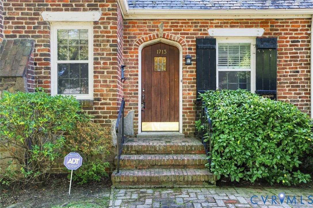 1713 Wilmington Avenue, Richmond, VA 23227 Brick facade with arched wooden entry door, brick steps, and wrought iron handrail