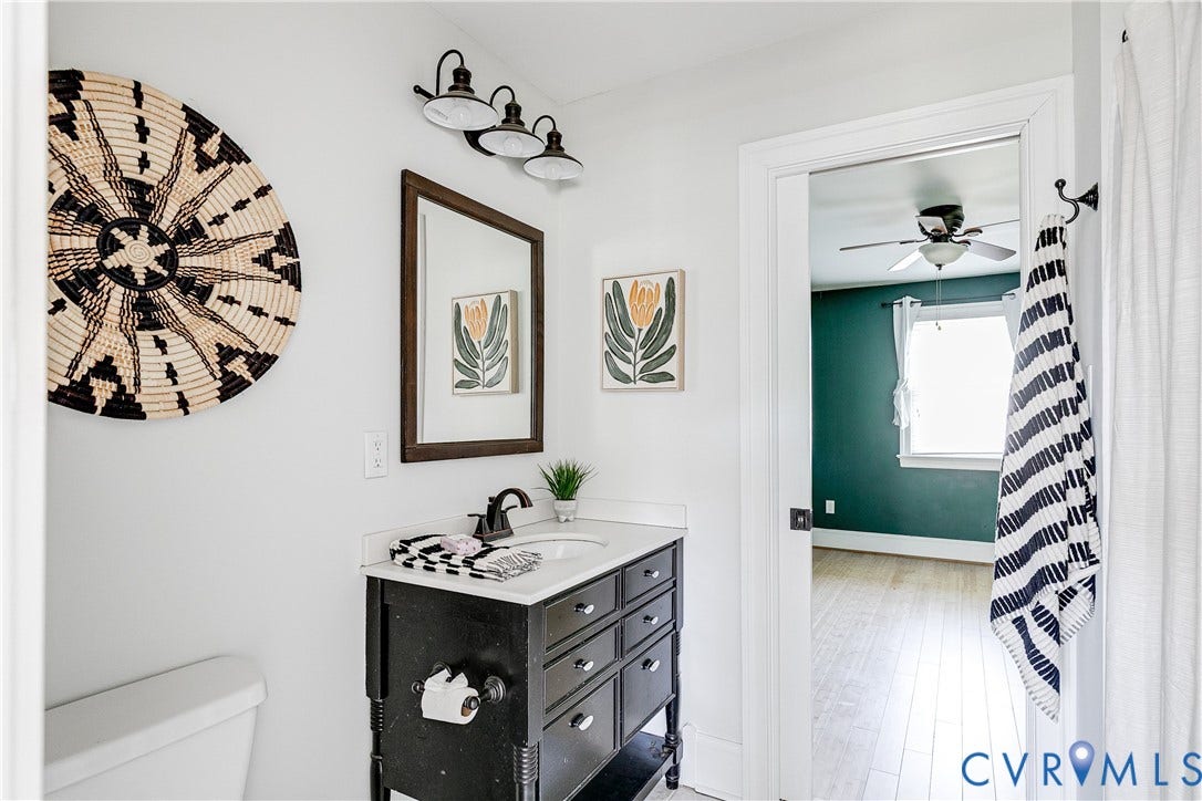 1311 N 33rd Street, Oakwood, Richmond, VA 23223 Bathroom featuring a dark wood-finish vanity with a white countertop and rectangular sink, complemented by a framed mirror and three-light vanity fixture