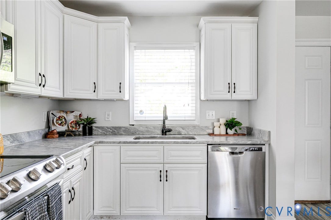 1311 N 33rd Street, Oakwood, Richmond, VA 23223 White shaker-style cabinetry, stainless steel dishwasher, undermount sink with a gooseneck faucet, and light-toned countertops