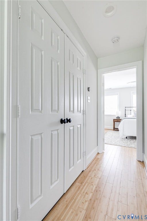 1311 N 33rd Street, Oakwood, Richmond, VA 23223 Light wood-finish flooring extending through a hallway with white paneled doors and black hardware