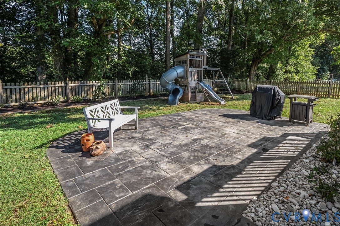 1206 Archie Lane, Osborne Heights / Varina, Henrico, VA 23231 Stamped concrete patio with a surrounding manicured lawn, picket fencing, and mature trees