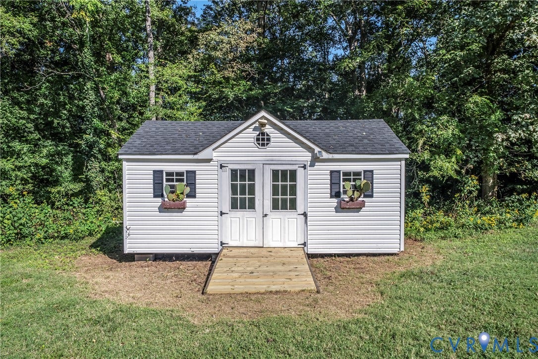 1206 Archie Lane, Osborne Heights / Varina, Henrico, VA 23231 White siding exterior with a dark shingle roof, featuring double doors, a round gable vent, and two windows with dark shutters and flower boxes