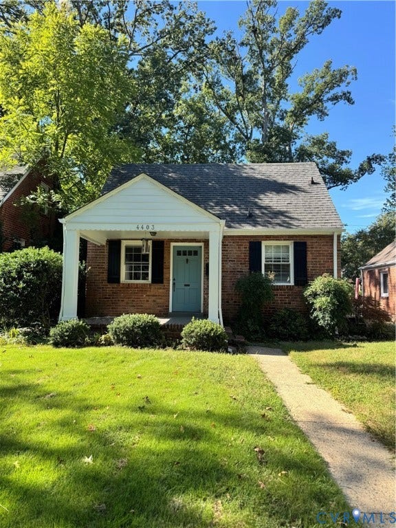 4403 Park Avenue, Richmond, VA 23221 Brick faade residence featuring a covered front porch, a light blue entry door, and dark window shutters