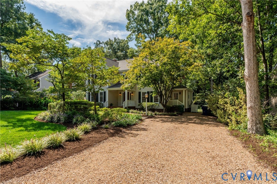 11211 Warren View Road, Henrico, VA 23233 Gravel driveway leading to a residence with a covered front porch, surrounded by mature trees and manicured landscaping