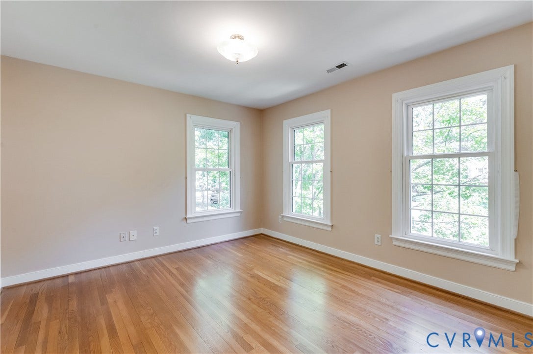 11211 Warren View Road, Henrico, VA 23233 Hardwood flooring, three multi-pane windows, neutral wall tones, white trim, and a ceiling-mounted light fixture