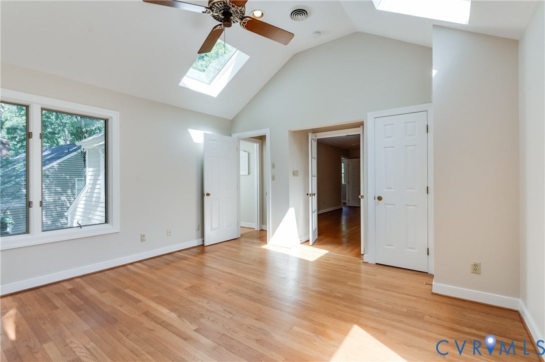 11211 Warren View Road, Henrico, VA 23233 Vaulted ceiling featuring skylights and a ceiling fan, wood-finish flooring, and white trim