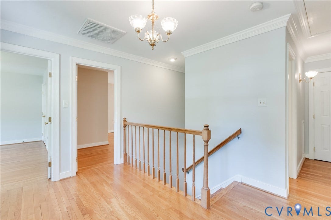 11211 Warren View Road, Henrico, VA 23233 Hardwood flooring, crown molding, and a chandelier illuminate the upper landing