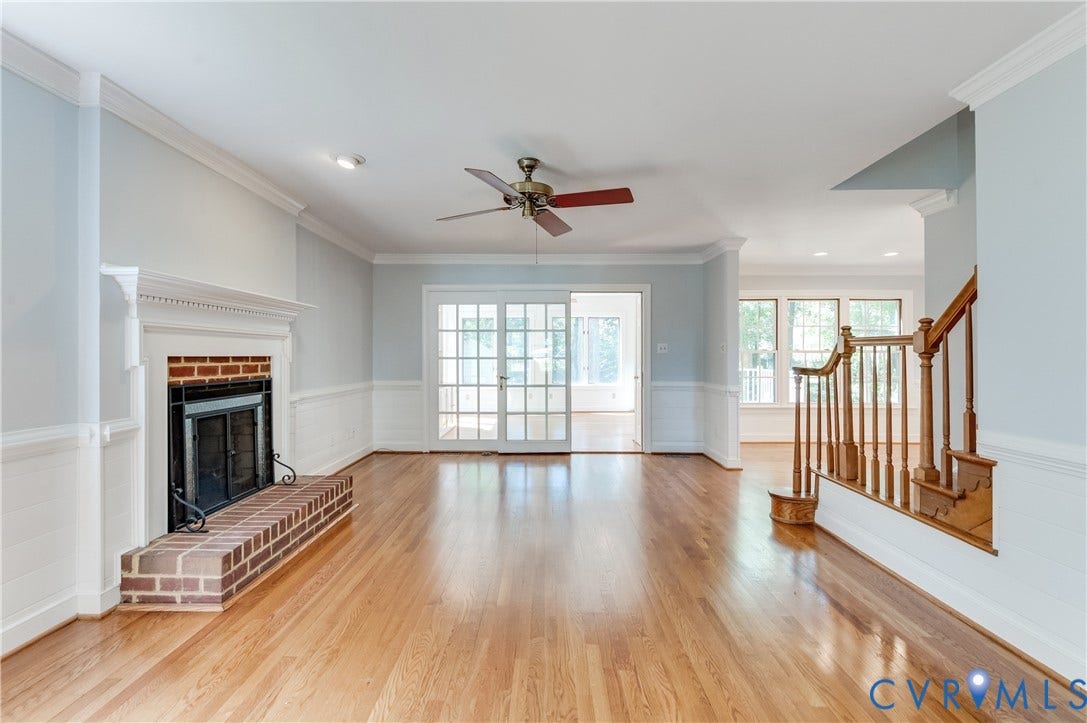 11211 Warren View Road, Henrico, VA 23233 Hardwood flooring throughout, a brick fireplace with a white mantel, white wainscoting, and a ceiling fan