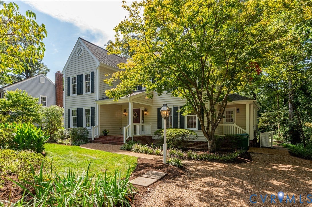11211 Warren View Road, Henrico, VA 23233 Traditional exterior with light siding and dark shutters, featuring a covered front porch with white railings, a gravel driveway, and a manicured lawn with mature trees
