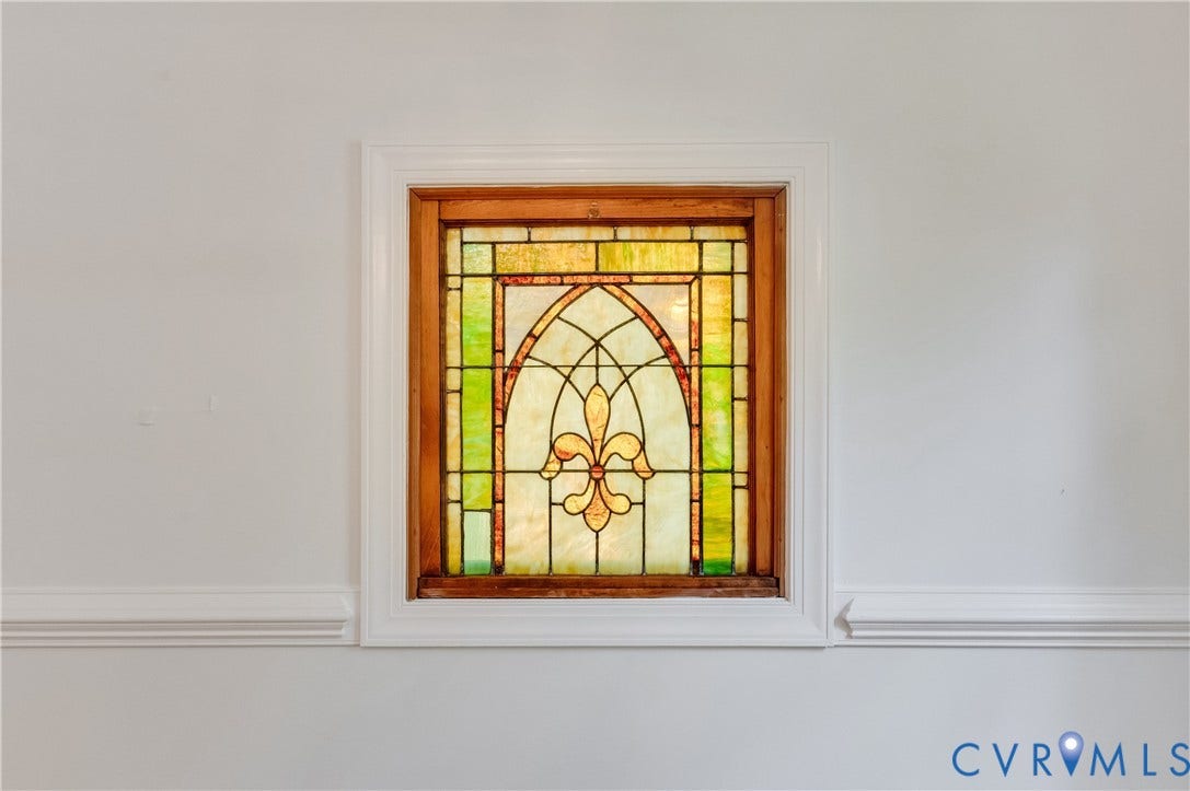 11211 Warren View Road, Henrico, VA 23233 Stained glass window with an arched design and a wooden frame, complemented by decorative crown molding