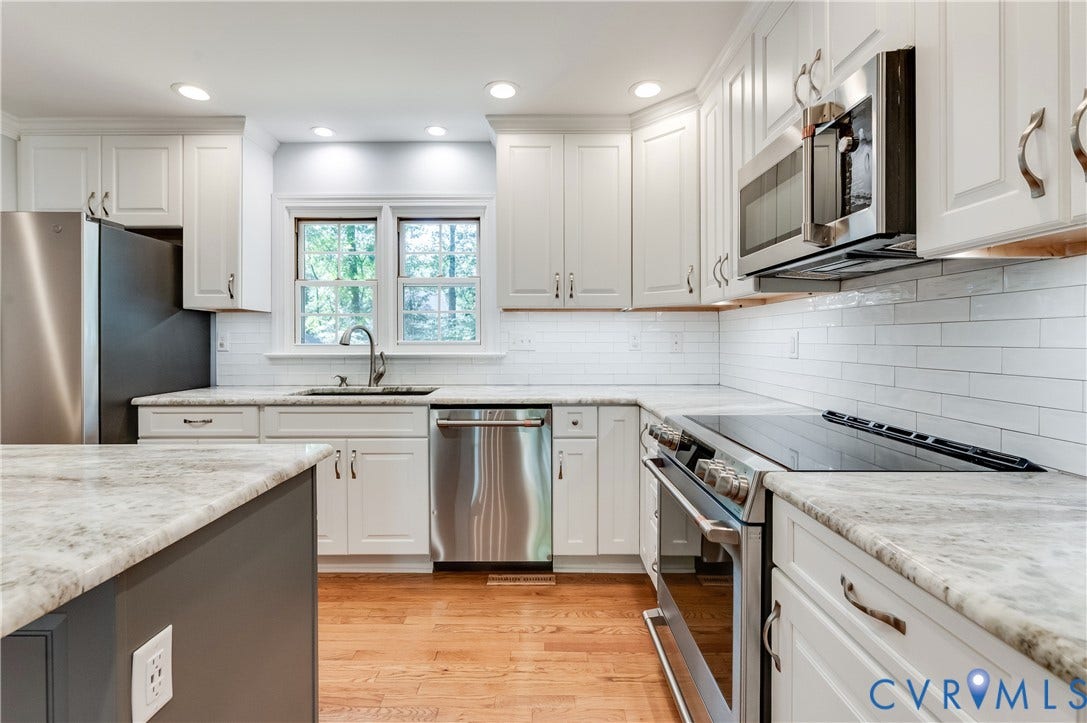 11211 Warren View Road, Henrico, VA 23233 Kitchen featuring white cabinetry, light-toned countertops, stainless steel appliances, a subway tile backsplash, and wood-finish flooring
