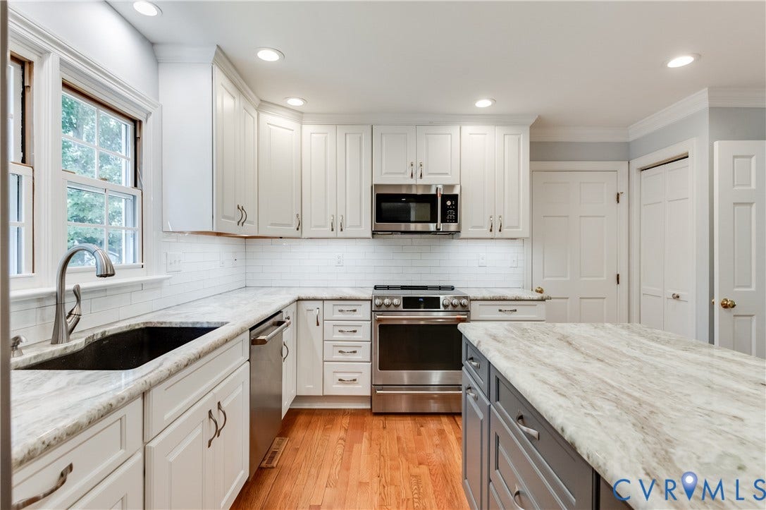 11211 Warren View Road, Henrico, VA 23233 Kitchen featuring white shaker cabinetry, stainless steel appliances, light-toned countertops, subway tile backsplash, and hardwood flooring