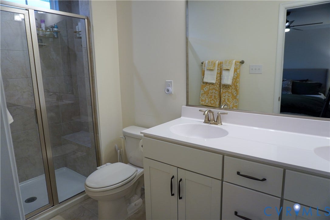 Walk-in shower with clear glass enclosure and tiled walls