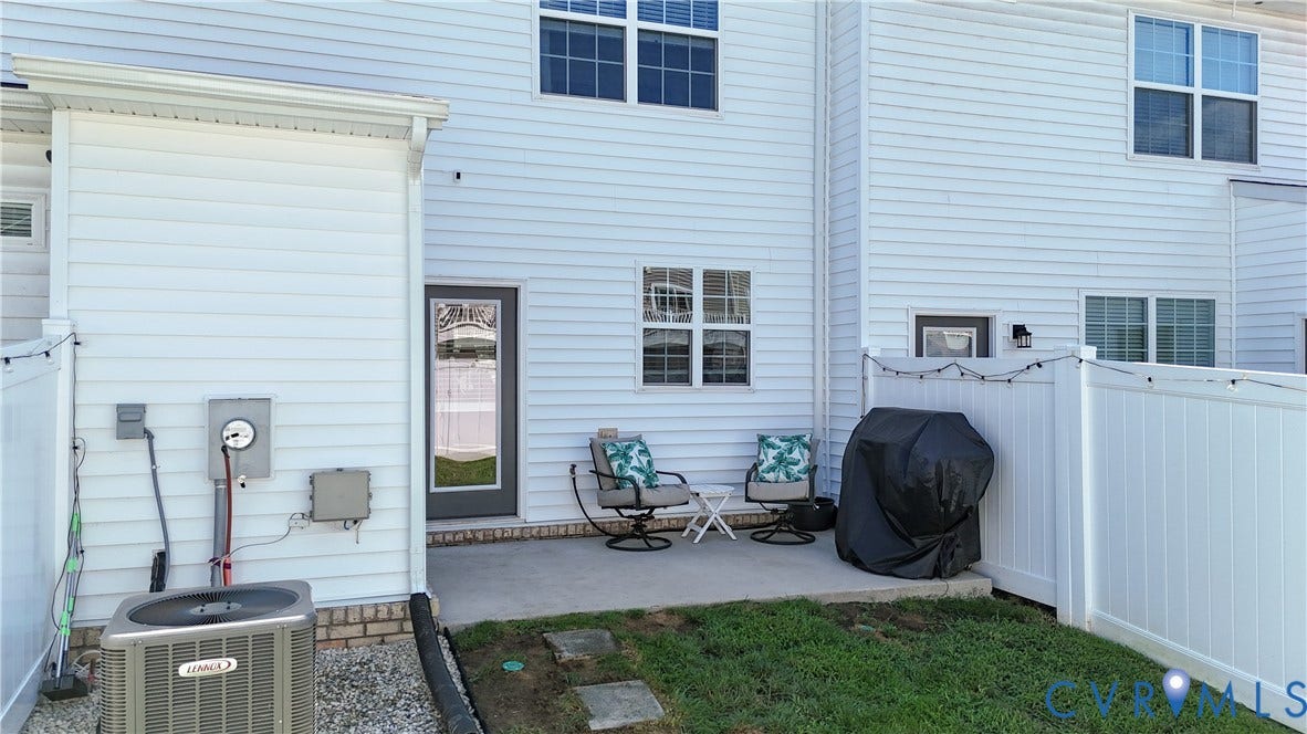 Private patio with a partial privacy fence and a rear exterior door