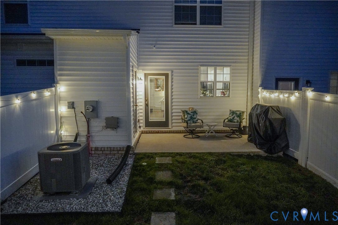 Private fenced backyard featuring a concrete patio, stepping stones, and a grass area