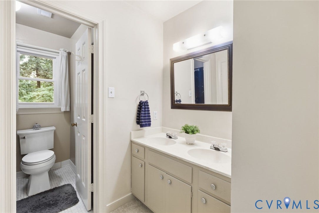 11805 Bedfordshire Square, Henrico, VA 23238 Dual sink vanity with ample countertop space, framed mirror, and a toilet alcove featuring a window