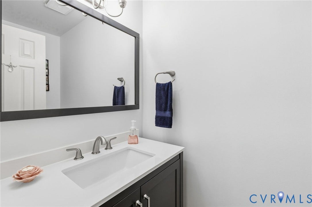 11805 Bedfordshire Square, Henrico, VA 23238 Built-in vanity with a white countertop and undermount sink, brushed nickel faucet, and a large framed mirror
