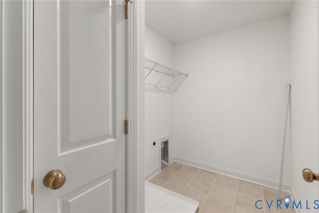 12506 Ashton Dell Road, Chester, VA 23831 White paneled door with brass hardware, tile flooring, and integrated wire shelving