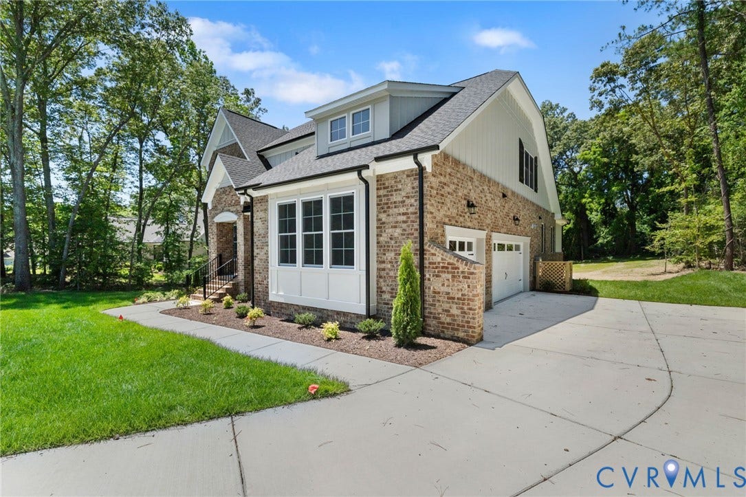 12506 Ashton Dell Road, Chester, VA 23831 Brick and siding exterior with a multi-pane bay window, attached two-car garage, dormer window, and mature trees