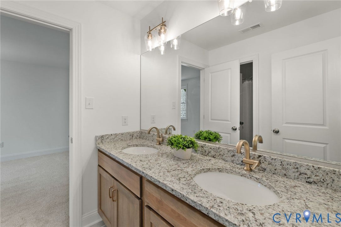 12506 Ashton Dell Road, Chester, VA 23831 Dual vanity with granite-style countertops, under-mount sinks, and gold-finish faucets