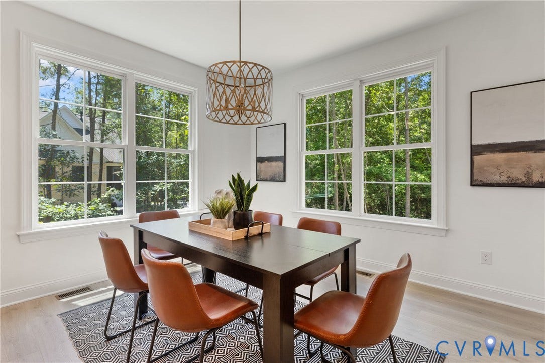 12506 Ashton Dell Road, Chester, VA 23831 Spacious room featuring multiple large windows, wood-finish flooring, and a unique pendant light fixture