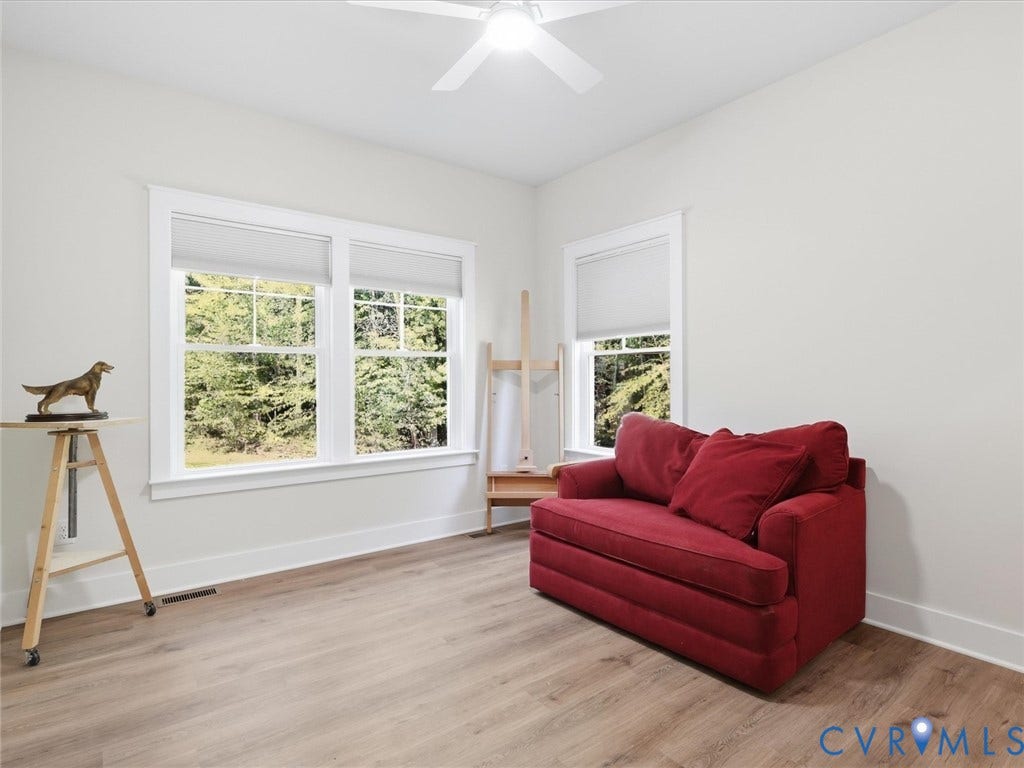 3102 Kensington Lane, Goochland, VA 23063 Bright room featuring wood-finish flooring, white walls, and multiple windows with white trim