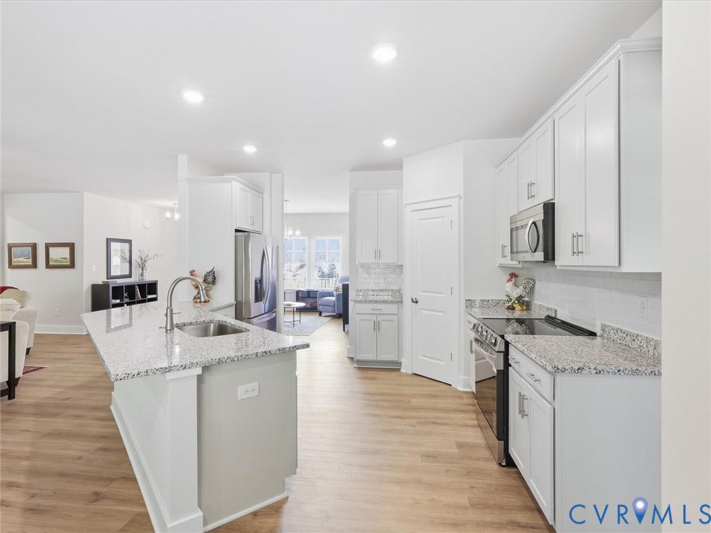 3102 Kensington Lane, Goochland, VA 23063 Kitchen featuring light wood-finish flooring, white cabinetry, stainless steel appliances, and granite countertops