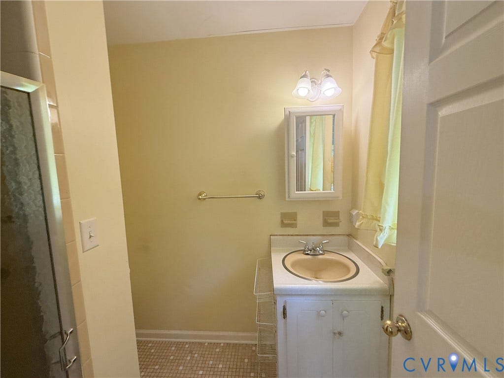 4512 Greenbriar Drive, Chester, VA 23831 White vanity with integrated sink, medicine cabinet with mirror, and a wall-mounted light fixture