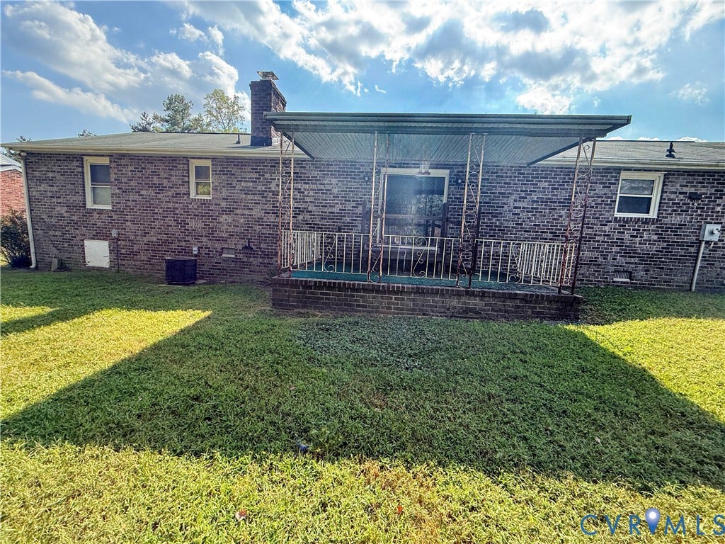 4512 Greenbriar Drive, Chester, VA 23831 Brick exterior featuring multiple windows and a covered patio with a decorative railing