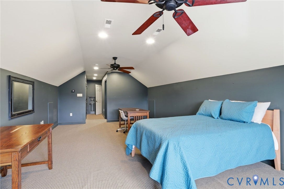 Carpeted room with sloped ceilings, recessed lighting, and two ceiling fans