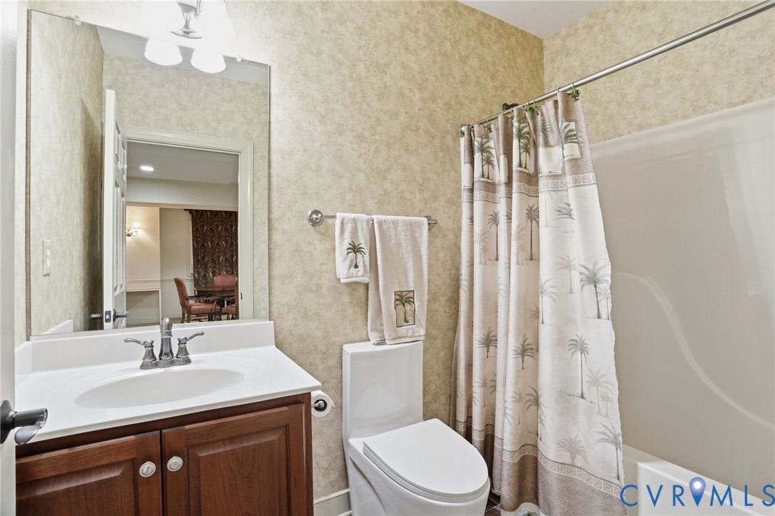 White vanity with an integrated sink, dual-handle faucet, and wood-finish cabinetry
