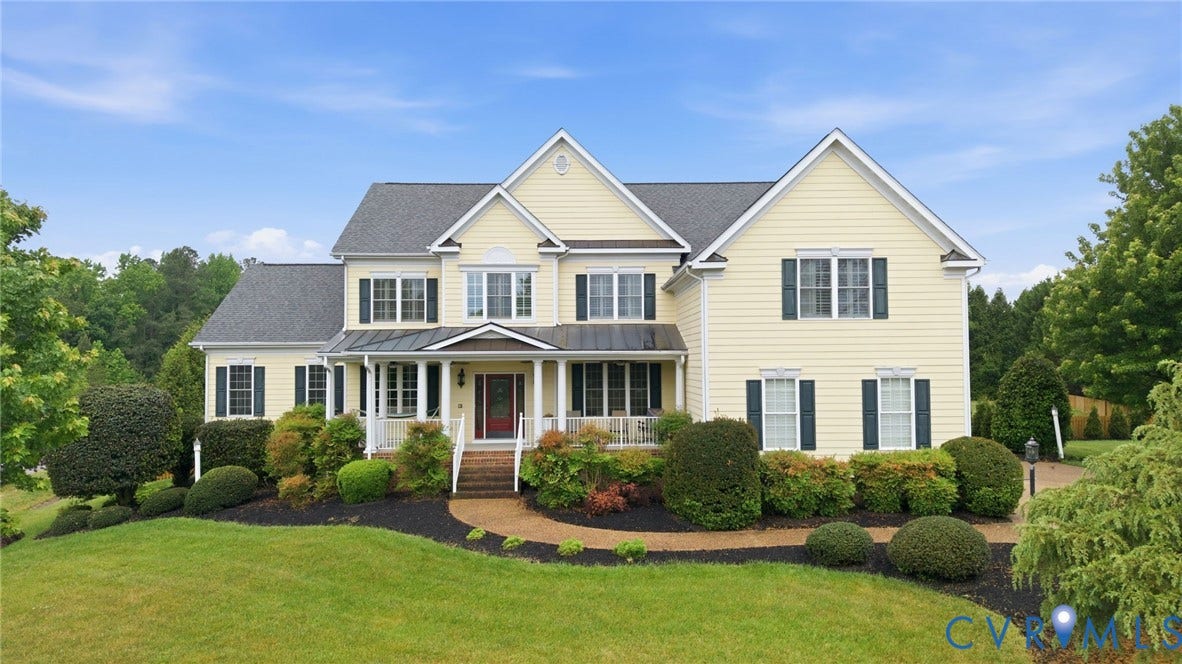 Expansive residence featuring a covered front porch, brick front steps, and multiple gables