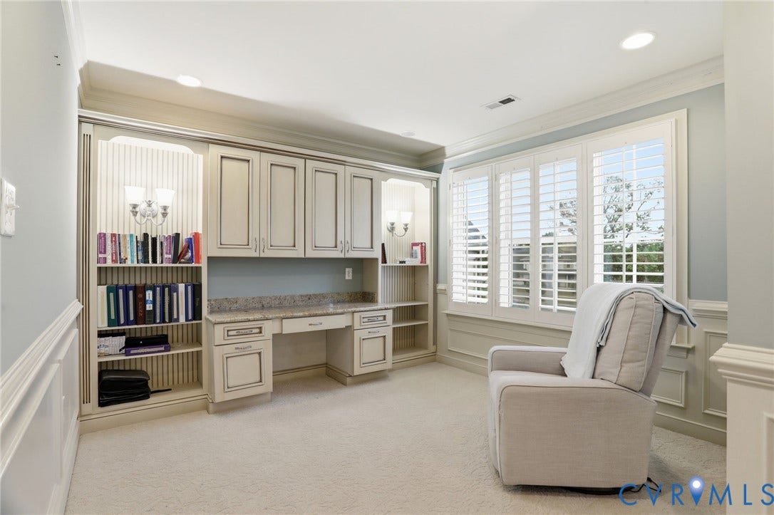 Built-in cabinetry with a granite-style countertop, integrated desk, and shelving
