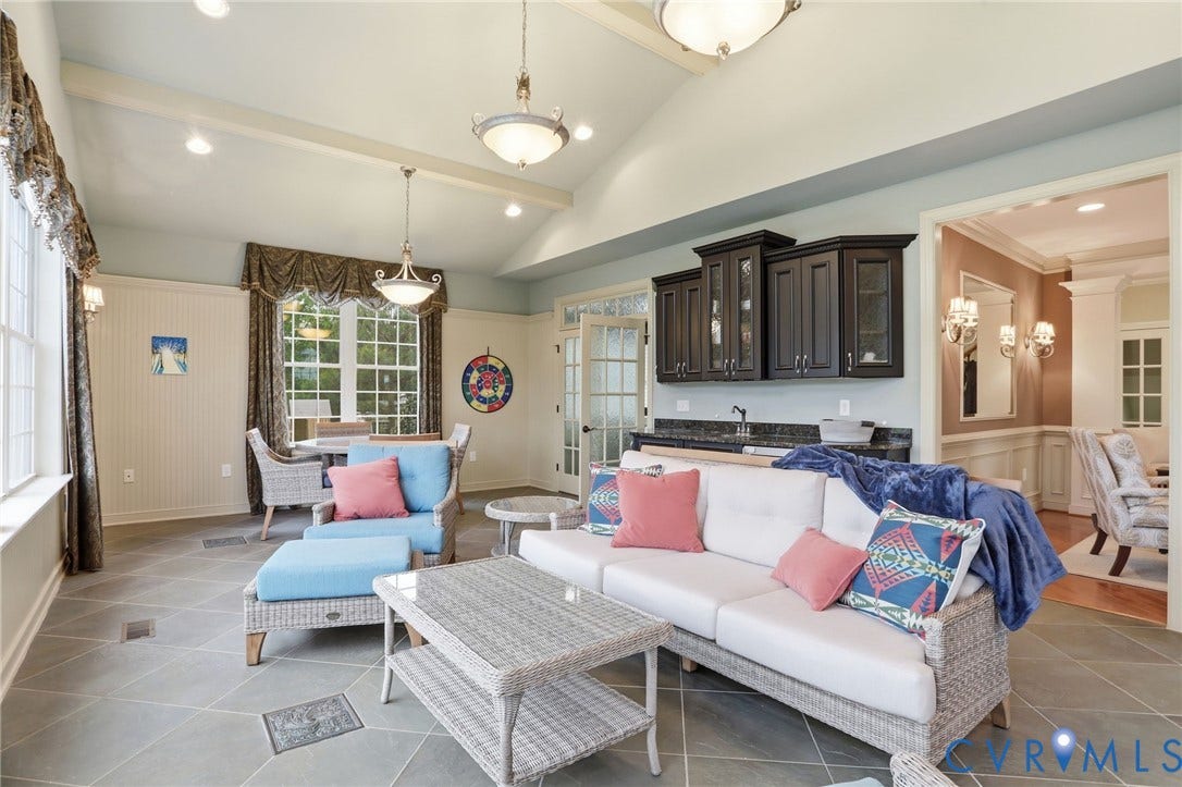 Vaulted ceiling with exposed beams, recessed lighting, and a built-in wet bar featuring dark cabinetry