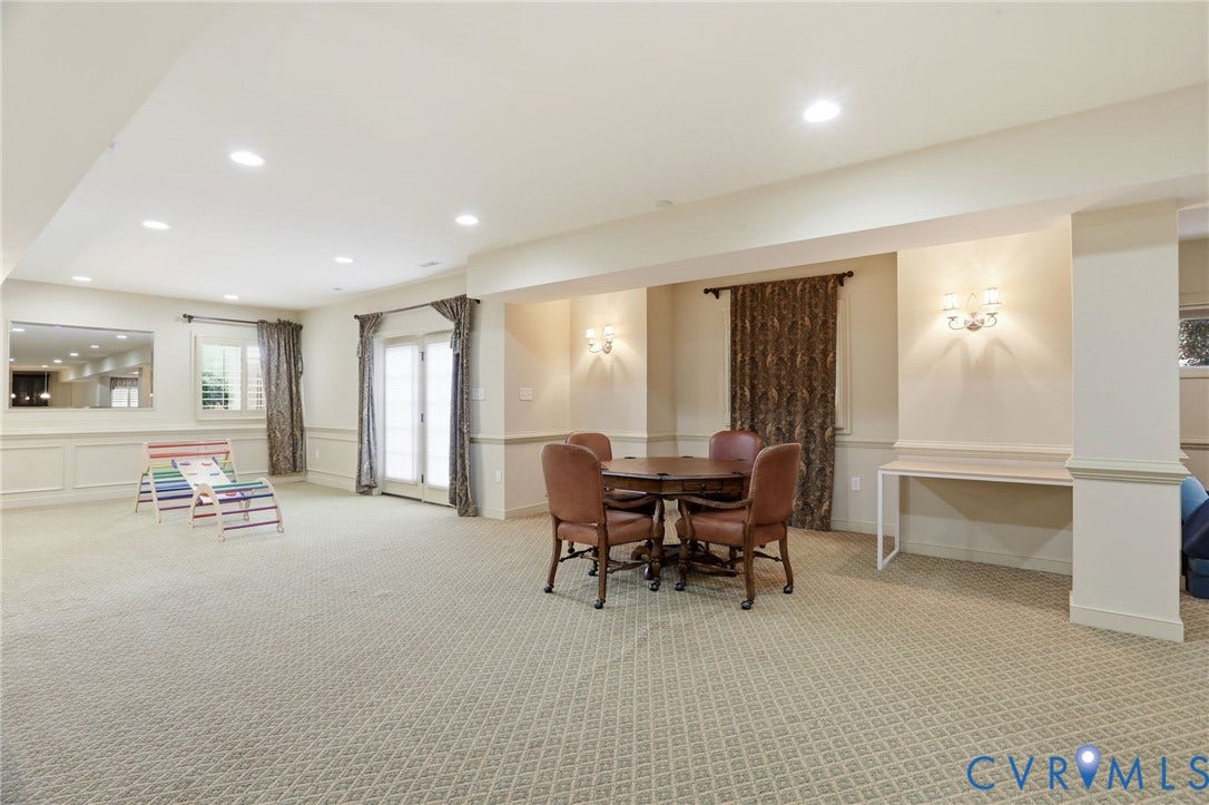 Expansive room featuring patterned carpeting, recessed lighting, and dual French doors