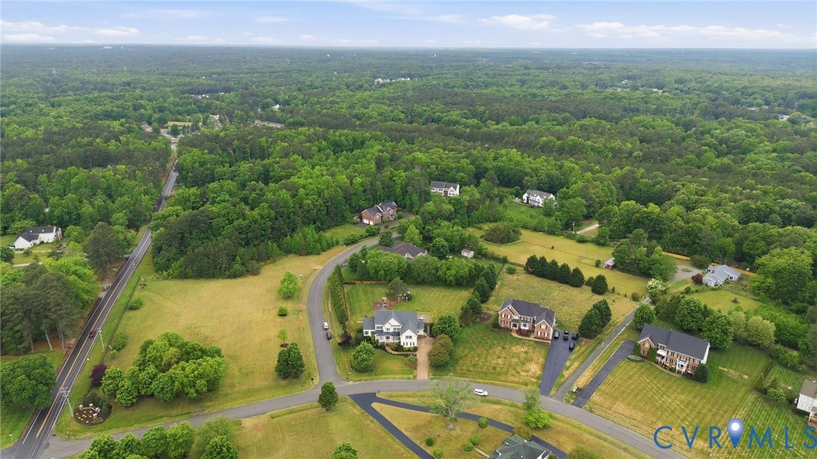 Expansive wooded landscape with residential properties and paved roadways