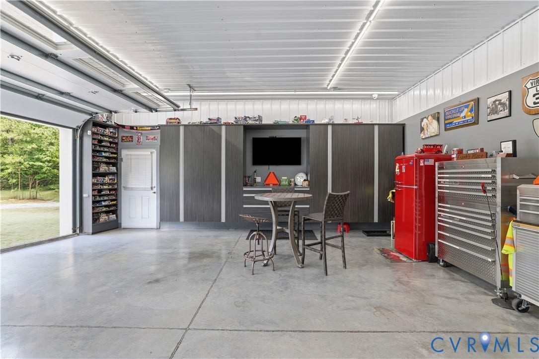 13114 Spring Road, Barr Brook Farms, Rockville, VA 23146 Spacious garage featuring a finished concrete floor, overhead lighting, an overhead door, and built-in cabinetry