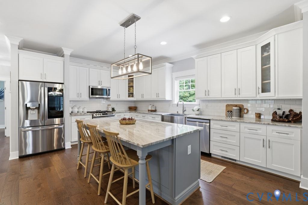 13114 Spring Road, Barr Brook Farms, Rockville, VA 23146 Spacious kitchen featuring white cabinetry, stainless steel appliances, a large center island with a light-toned countertop, and rich wood-finish flooring