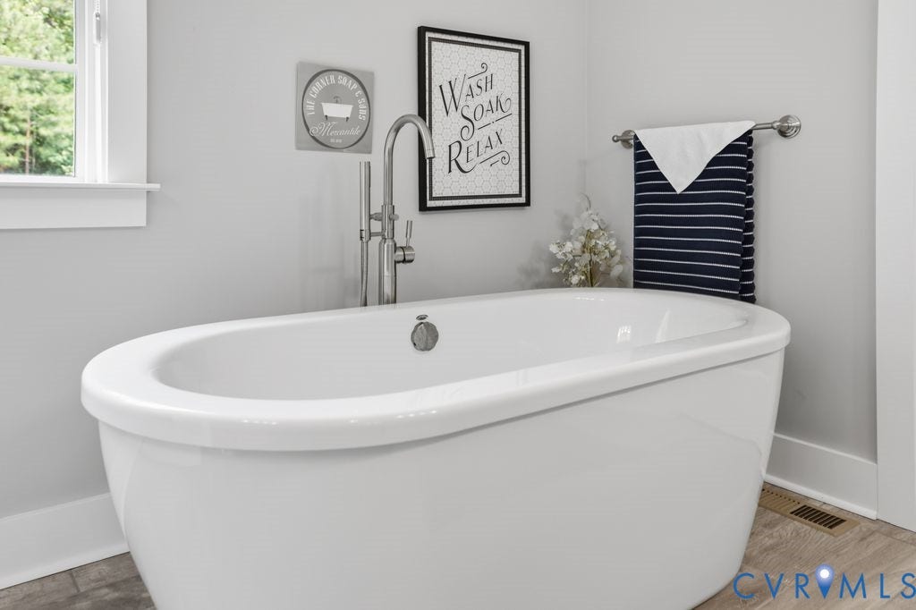 13114 Spring Road, Barr Brook Farms, Rockville, VA 23146 Freestanding soaking tub with floor-mounted chrome faucet, wood-finish flooring, and white window trim