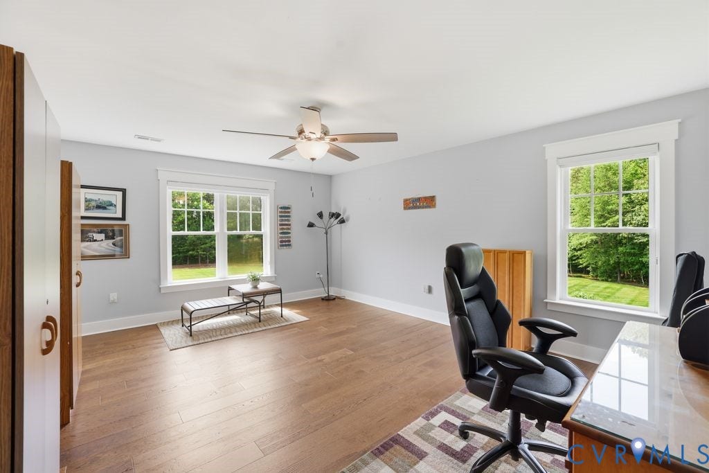 13114 Spring Road, Barr Brook Farms, Rockville, VA 23146 Spacious room with wood-finish flooring, two large double-hung windows, a ceiling fan with integrated lighting, and light gray wall paint