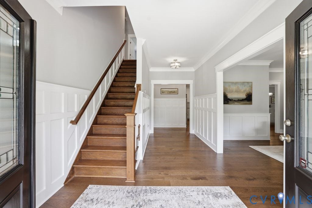 13114 Spring Road, Barr Brook Farms, Rockville, VA 23146 Wood-finish flooring throughout, framed doorways, wainscoting, a wood staircase with white risers and railing, and an overhead flush-mount light fixture