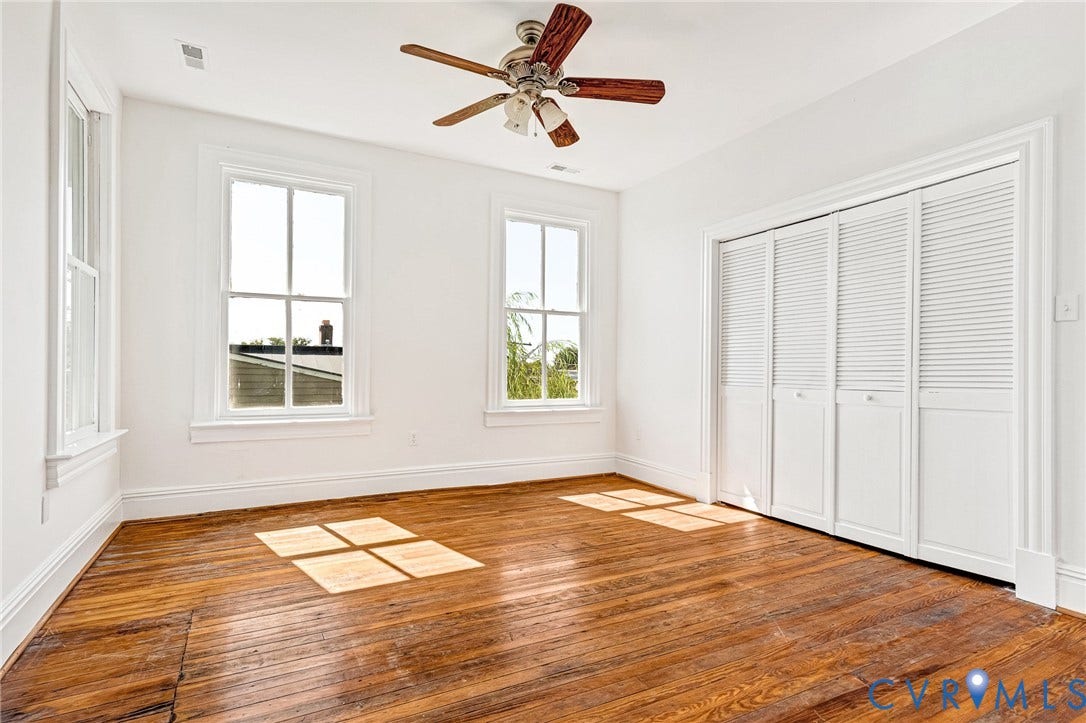 615 N 23rd Street, Church Hill Central, Richmond, VA 23223 Wood-finish flooring, white walls, two double-hung windows, and a ceiling fan with wood-finish blades